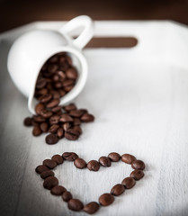 cup of coffee and beans on wooden background