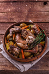 Rabit with root vegetables and herbs on wooden background, copy space