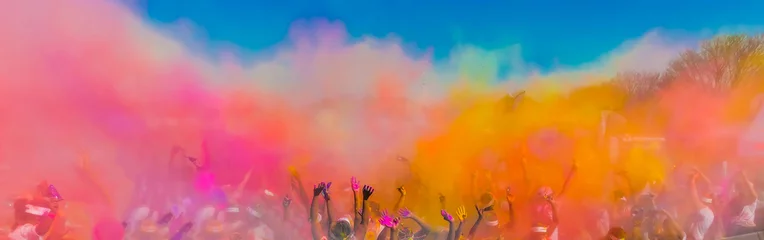 Tuinposter Crowd throwing bright coloured powder paint in the air, Holi Festival Dahan. © Sunshine Seeds