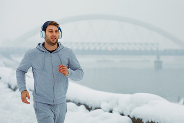 Young man jogging on a snowy day