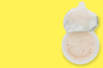 Single plastic jar of pate on yellow background with copy space for your text