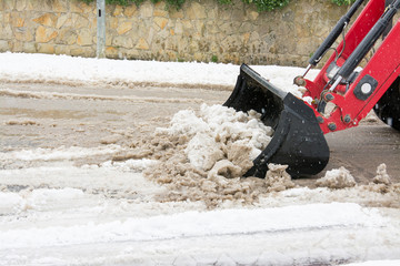 Wheel loader machine removing snow in winter on the road