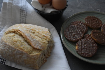 Pan hecho a mano, plato con galletas de chocolate, huevos ecológicos 