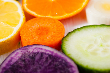 Naklejka na ściany i meble sliced fruits and vegetables on white wood table background