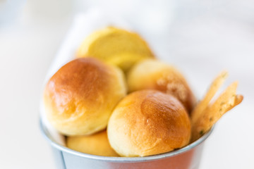 Rolls and various type of breads in silver bucket served at dinning table