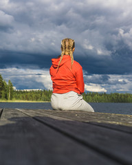 Nainen istuu laiturilla