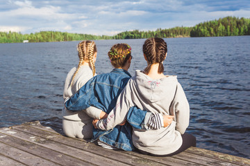 Girls sitting on dock with braided hair