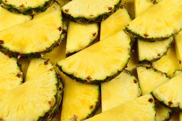 Pineapple juicy yellow slices background. Top view.