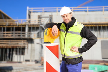 Bauarbeiter lehnt auf Barke vor Baustelle