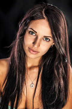 Sexy brunette woman with bronze tan wearing diamond necklace.