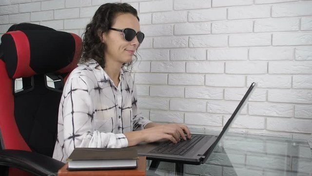 Good effect of pinhole glasses. A woman works at a laptop with obscura glasses.