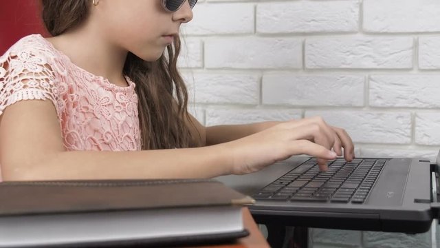 Hppy child wearing pinhole glassess. Teenage girl at a laptop in pinhole glasses.