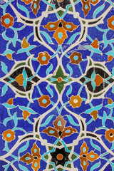 Colorful mosaic and ceramic tiles in the traditional Persian style on the wall of the Jameh Mosque of Isfahan, Iran.