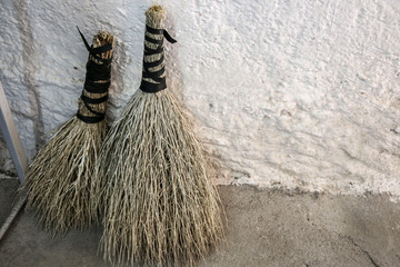 Natural handmade brooms  near white plain wall
