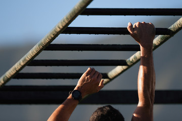 Mud race running over obstacles race runners,hands overcome obstacle.Hand over hand