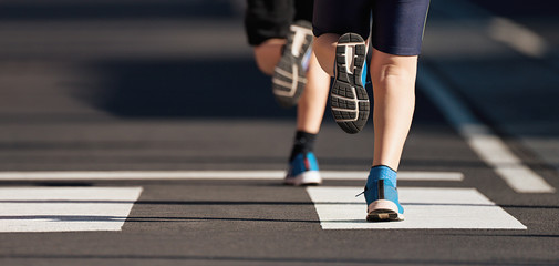 Running children, young athletes run in a kids run race,running on city road detail on legs,running in the light of morning