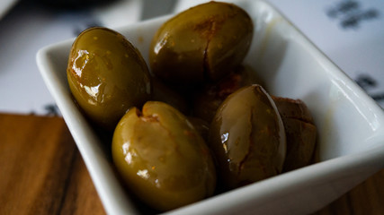 Container of spicy green olives