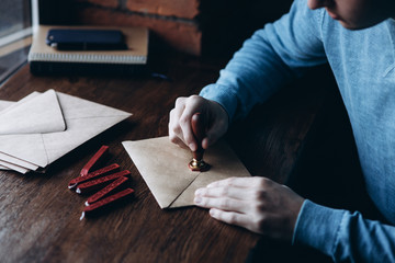 Close up view of using sealing wax on the envelope. Stamp