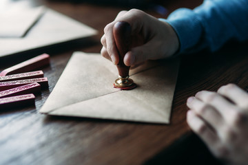 Close up view of using sealing wax on the envelope. Stamp