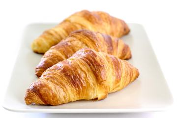 Three croissants on a white plate