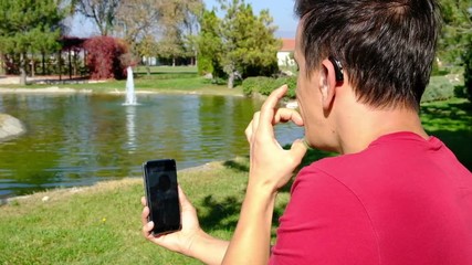 Young boy communicating with sign language  at smart phone