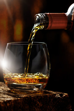 
Pour whiskey out of the bottle in whiskey glass
