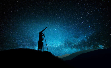 Silhouette of little child looking through a telescope © ginettigino