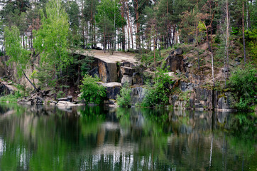 Fototapeta na wymiar Beautiful landscape of trees and a pond in stone rocks,