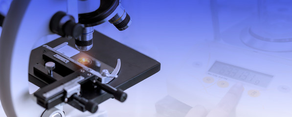 Close-up shot of microscope with laboratory equipment background