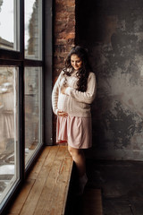 Beautiful pregnant woman in rose sweater