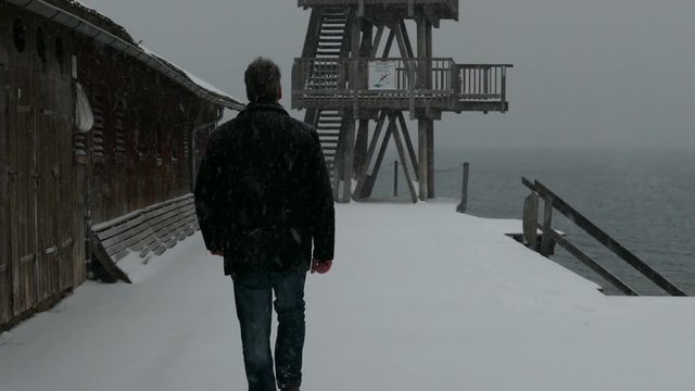 Winter in bayern, ammersee, mann am ufer in utting, schnee, sturm