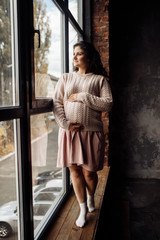 Fototapeta na wymiar Beautiful pregnant woman in rose sweater