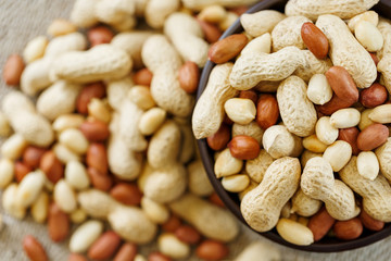Peanuts in the shell and peeled closeup in a cup