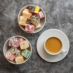 Turkish delight and cup of coffee on grey background. Top view