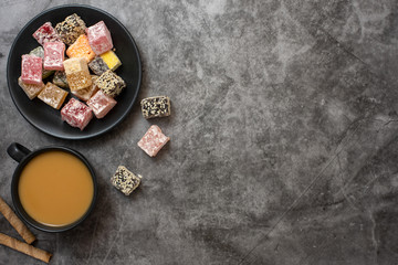 Traditional turkish delight and cup of coffee on grey background. Flat lay. With copy space