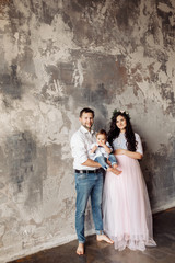 Obraz na płótnie Canvas Pretty family with small son in the photo studio