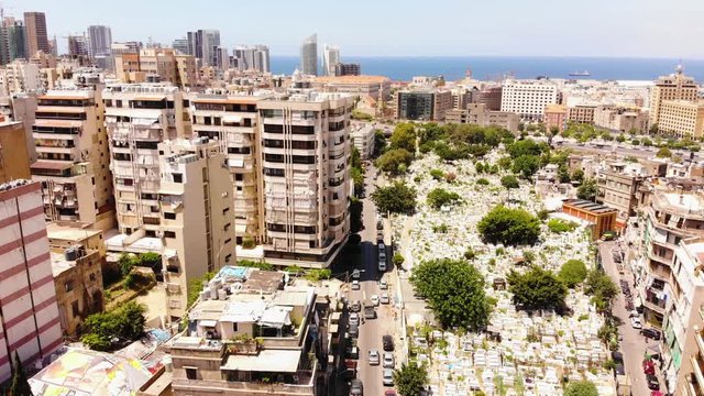Bashoura Muslim Cemetery, Beirut, Lebanon aerial footage. Muslim cemetery in the middle of a big city with skyscrappers and cars around.Beirut skyline with skyscrappers, drone footage.
