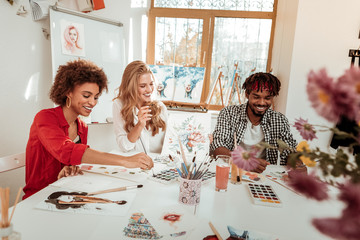 Talented artists laughing while feeling funny working together