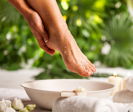 Foot spa on a tropical green leaves background
