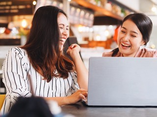 two women using digital tablet at home