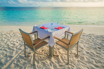 Table outdoor next to sea scenic prepare for special romantic dinner time.