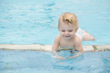 Portrait of a happy baby girl in the swimming pool 