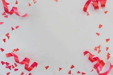 close up on red and pink color  rolling ribbon and confetti on white background with copy space for festival carnival design	