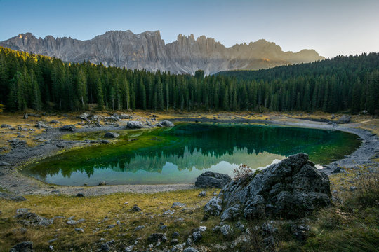 Reflection of Latemar in the clear water of Lake Carezza Karersee in Dolomite Alps, Trentino Alto Adige, South Tirol, Italy