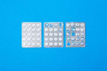 Pills and capsules. Paper blue background. Top view.
