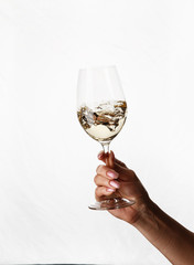 hand holding a glass of white wine