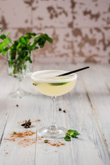 An alcohol cocktail with lime in glass on white background