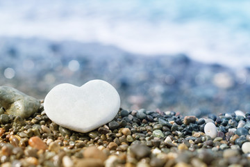 Heart of stone on the beach, close-up, selective focus. Romantic image for the day of lovers
