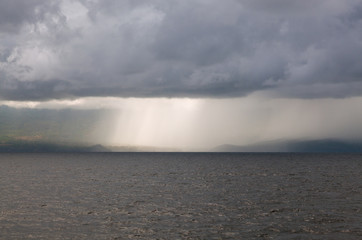 Clouds and rain in the ocean near a tropical island