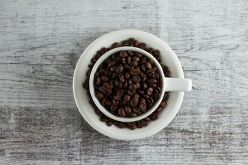 cup of coffee with beans on wooden background